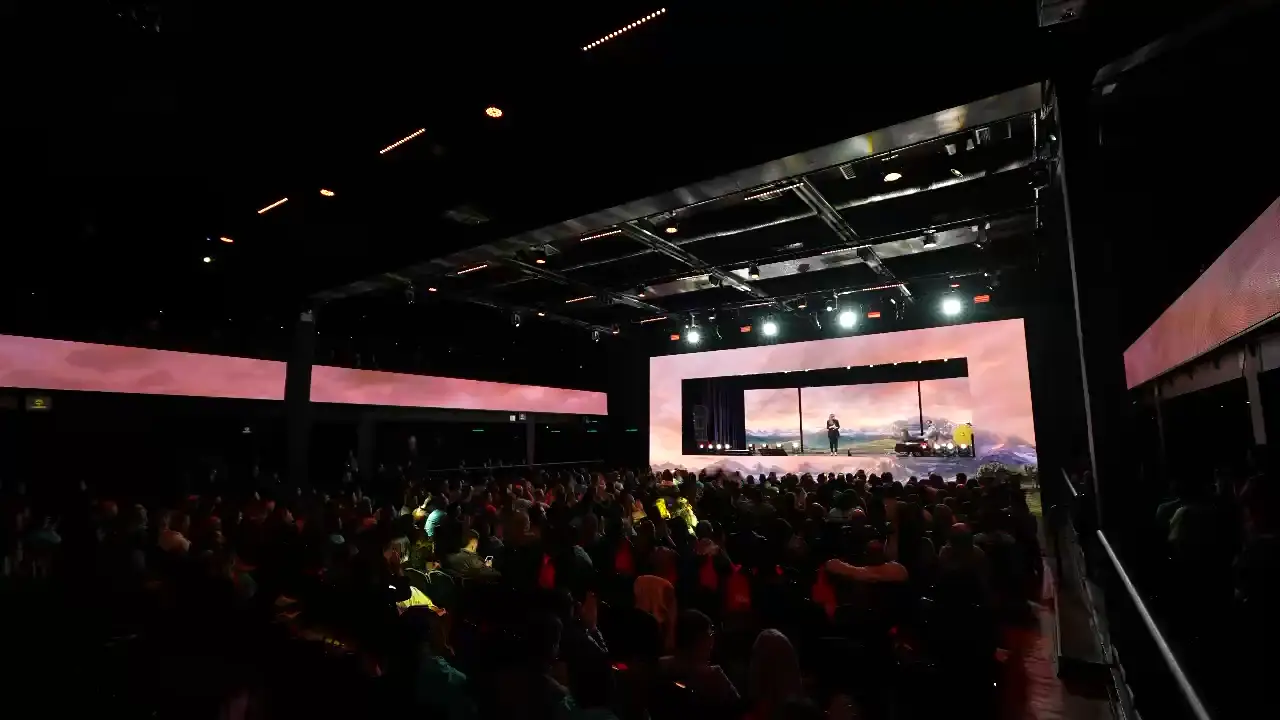 Salão de evento com palco e estrutura de treliça montada pela Yes Audiovisual